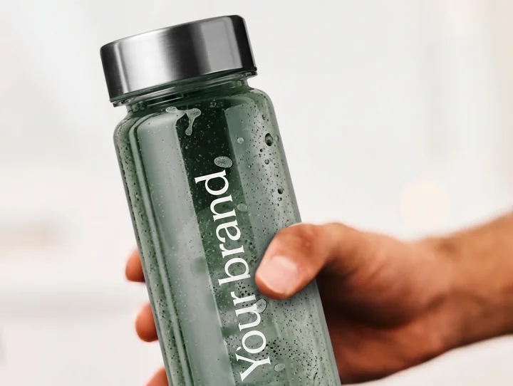 A hand holding a supplement bottle carrying the partner&rsquo;s own branding